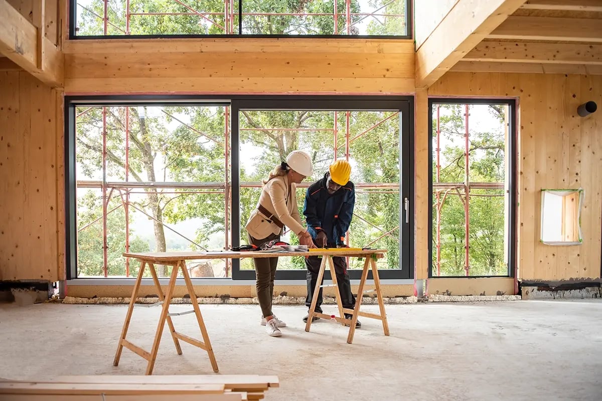 man-woman-in-hard-hats-looking-at-plans