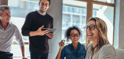 A diverse group of people sitting around a table, smiling and engaging in conversation