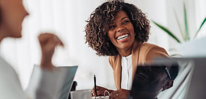Business professional happily participating in a business conference call at her desk