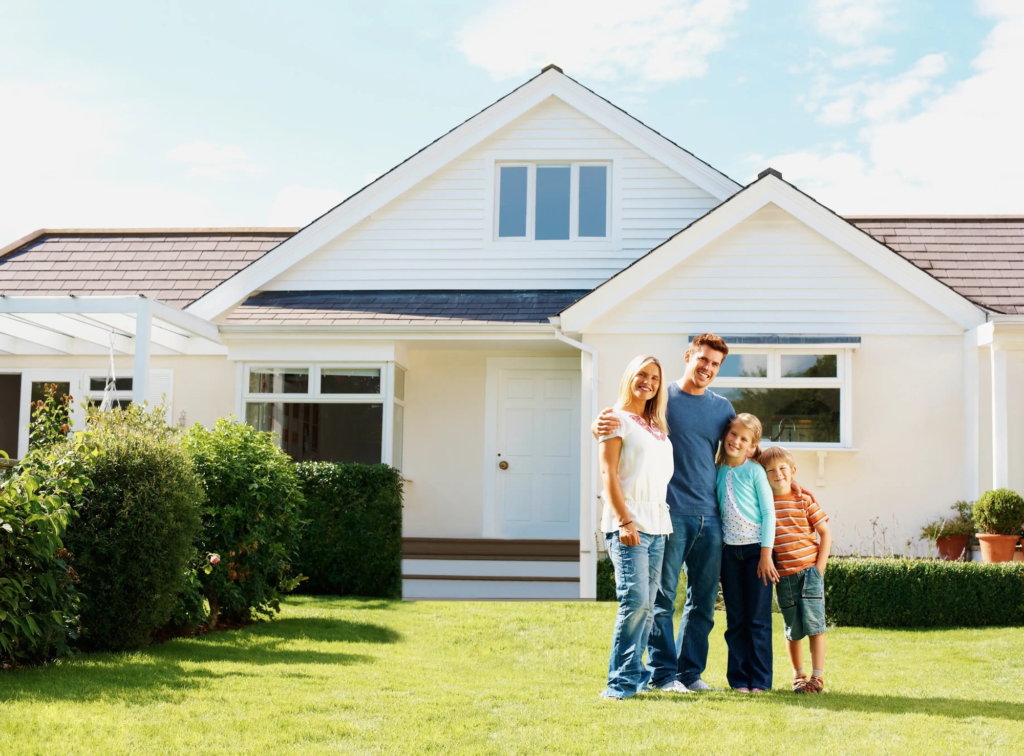Young family holding the keys to their new home and celebrating their purchase