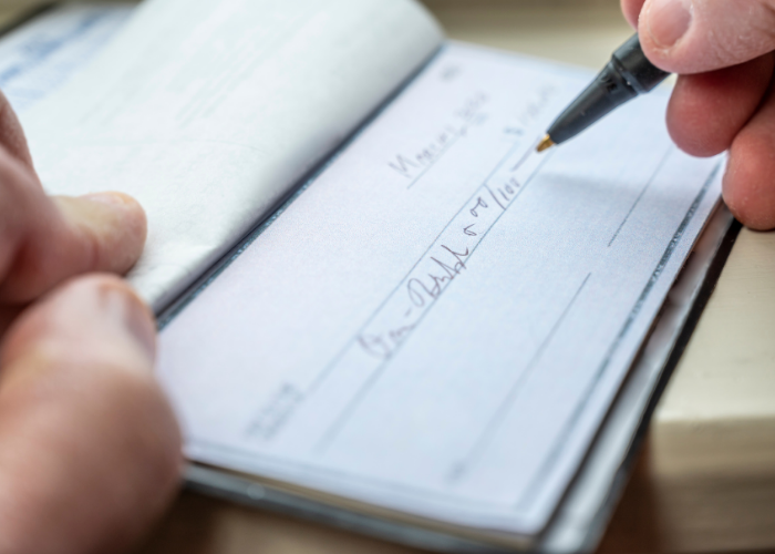 Closeup of person writing check.