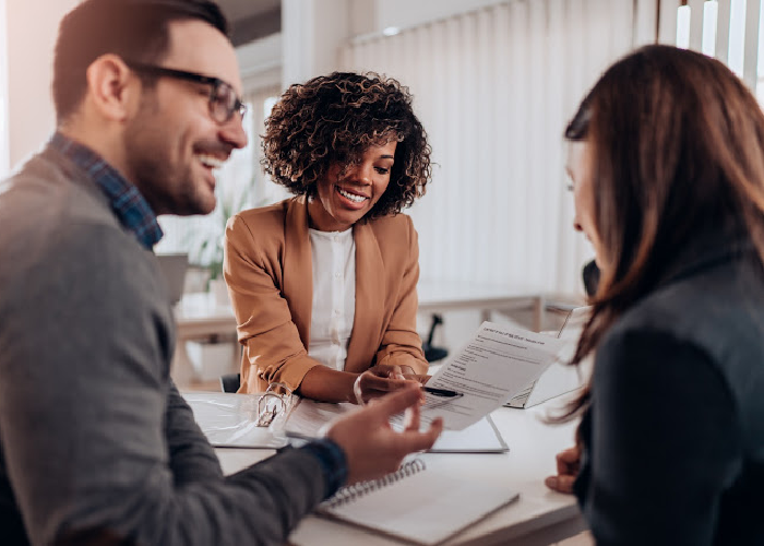 couple meeting with financial advisor and reviewing documents