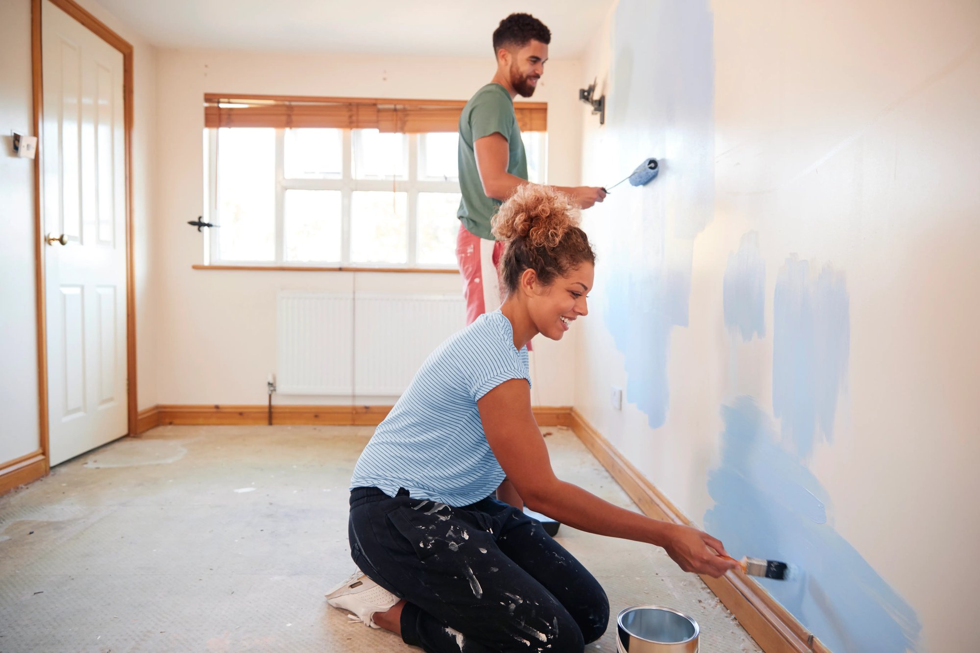 Couple painting the walls of their new home.