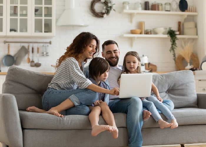 family-looking-at-computer-on-couch