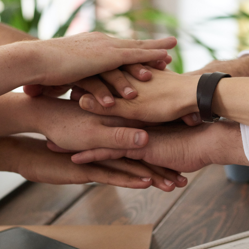 Hands stacked together for teamwork.