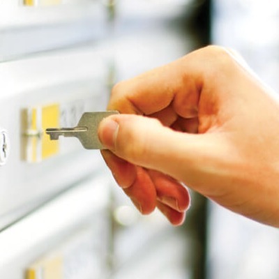 Person using a key to open a lockbox.