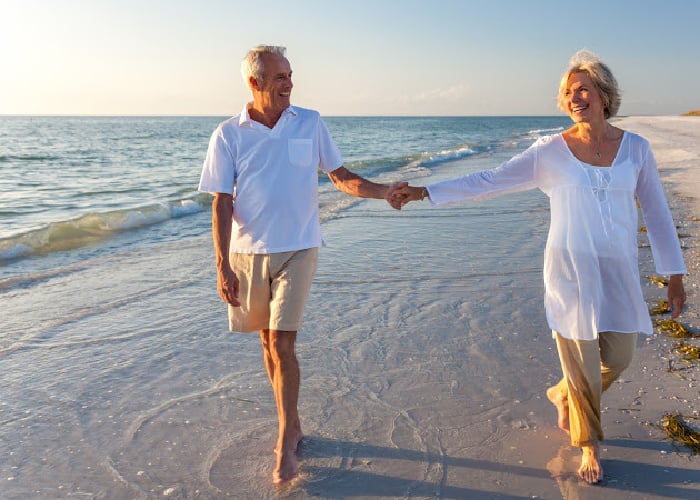 older-man-woman-walking-on-beach