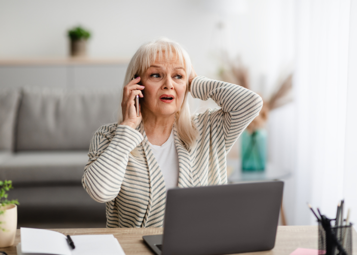 Concerned woman on the phone, sitting at a desk.