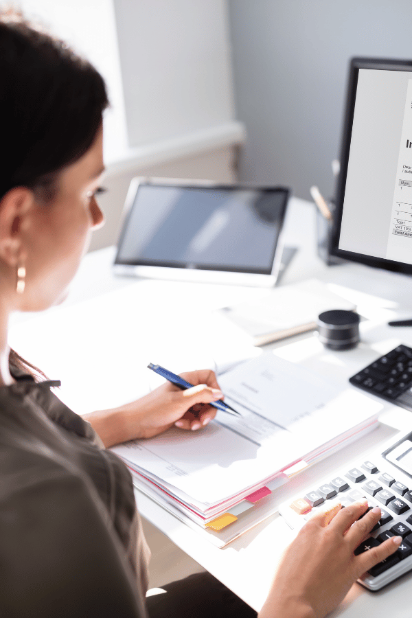 woman-at-aa desk-on-calculator-vertical