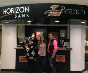 Three women stand in from the Horizon Bank Slicer Branch.
